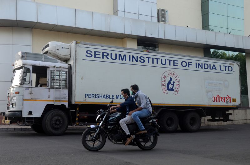 &copy; Reuters. Dos hombres pasan en una motocicleta frente a un camión del Instituto Serum en Pune