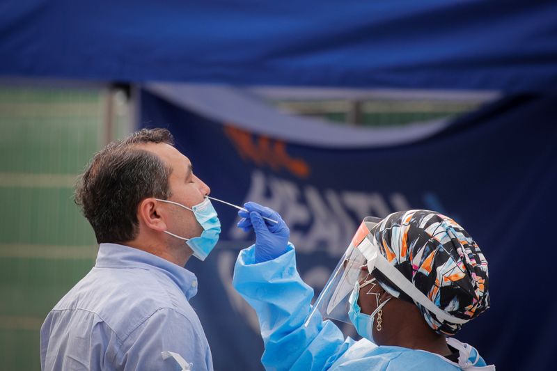 &copy; Reuters. A health worker takes a swab sample from a man to test for the coronavirus disease (COVID-19) in the Borough Park in Brooklyn, New York