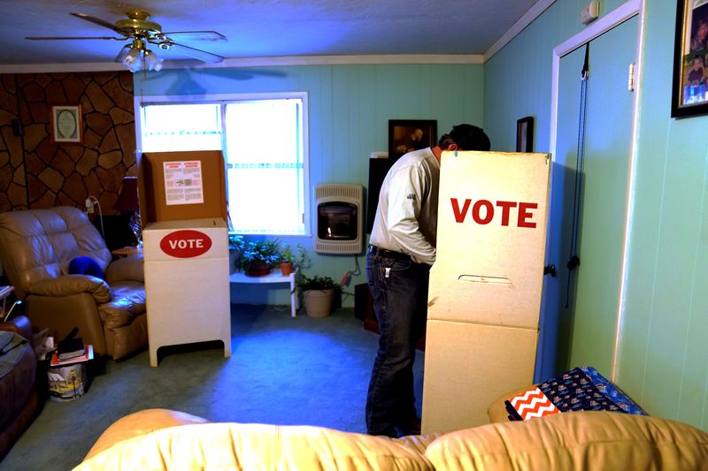 © Reuters. A voter fills out his ballot in Margaret Johnson's living room, which serves as voting place, on Super Tuesday in Allen