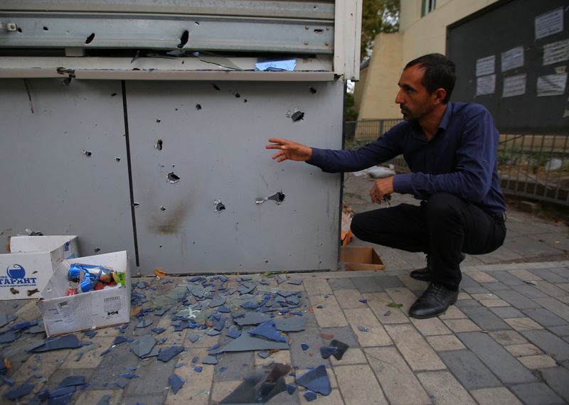 &copy; Reuters. Un hombre posa junto a una estructura dañada en Tartar