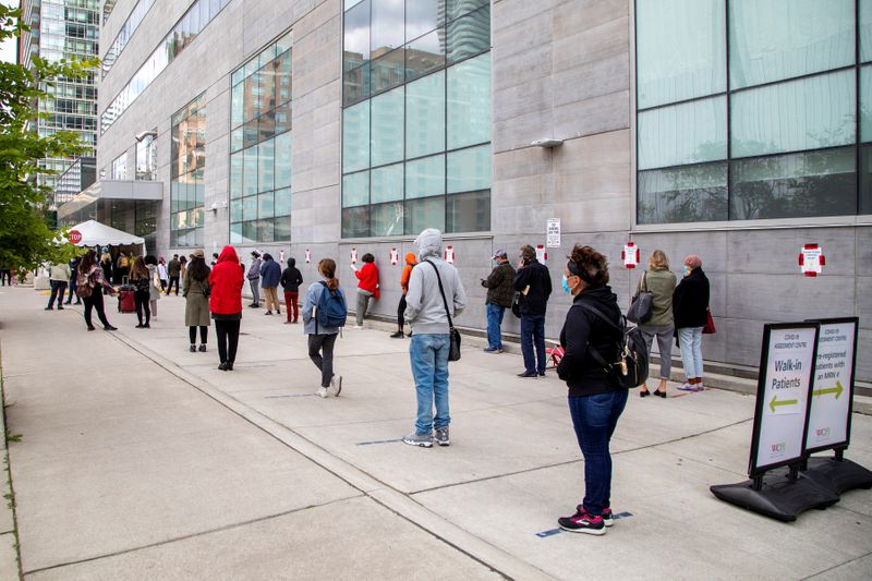 &copy; Reuters. FILE PHOTO: People wait in line at a coronavirus disease (COVID-19) testing facility in Toronto.
