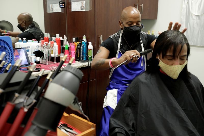 © Reuters. FILE PHOTO: Gary Connell cuts a customer's hair in the aftermath of a nine-week disruption to his hairstyling business due to the stay-at-home order for the coronavirus disease (COVID-19) outbreak, at Salon Plaza in Wheaton, Maryland