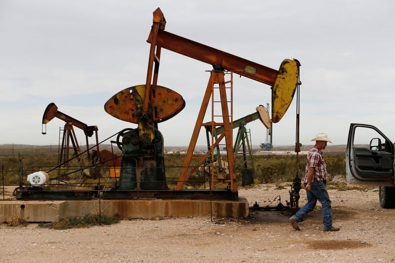 &copy; Reuters. Paul Putnam, 53, a rancher and independent contract pumper walks past a pump jack in Loving County