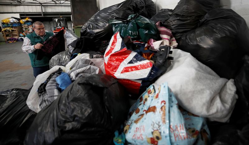 &copy; Reuters. Antonio de Carvalho from Green World Recycling sorts through bags of clothing at the company&apos;s facility in Stourbridge, Britain