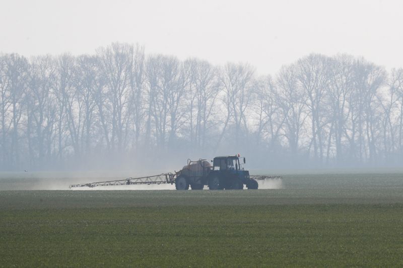 &copy; Reuters. An agricultural worker drives a tractor spreading fertilizers to a field of winter wheat in Kiev region