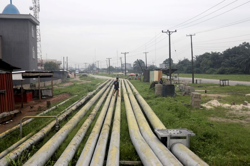 &copy; Reuters. A woman walks over pipelines crisscrossing Ogoniland in Rivers State