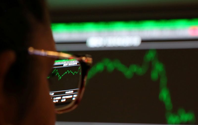 &copy; Reuters. FILE PHOTO: A woman looks at an electronic board on the floor of Brazil&apos;s B3 Stock Exchange in Sao Paulo