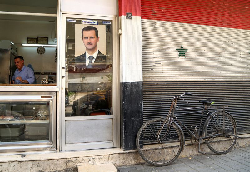 © Reuters. FILE PHOTO: A picture of Syrian President Bashar al-Assad is seen on a door of a butcher shop, during a lockdown to prevent the spread of the coronavirus disease (COVID-19), in Damascus