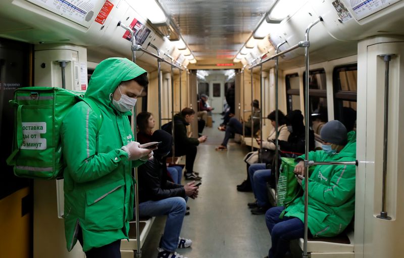 &copy; Reuters. Ruslan, 22, a courier of Delivery Club food delivery service rides an underground train in Moscow