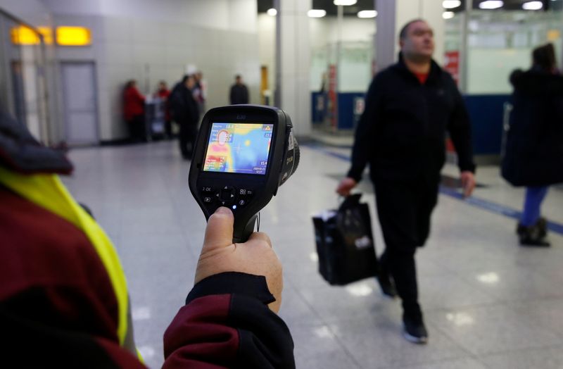 © Reuters. Kazakh sanitary-epidemiological service worker uses a thermal scanner to detect travellers from China who may have symptoms possibly connected with the previously unknown coronavirus, at Almaty International Airport