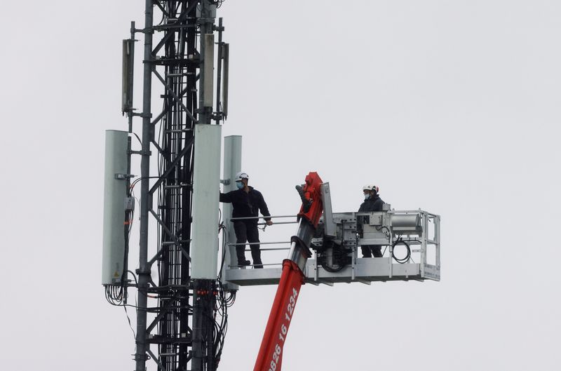 &copy; Reuters. Technicians work at the top of transmitting antennas are seen on a mobile-phone network relay mast in Lambres-lez-Douai