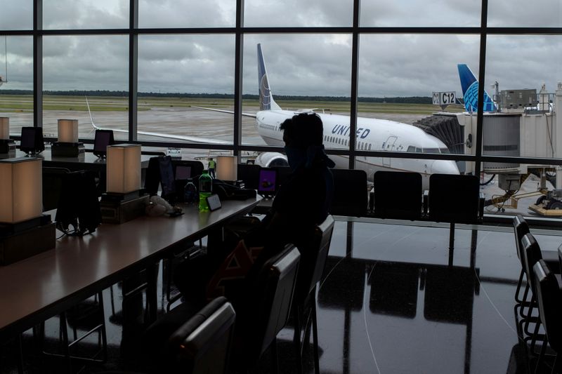 &copy; Reuters. FILE PHOTO: United Airlines plane is seen in the background as a passenger sits in IAH George Bush Intercontinental Airport in Houston