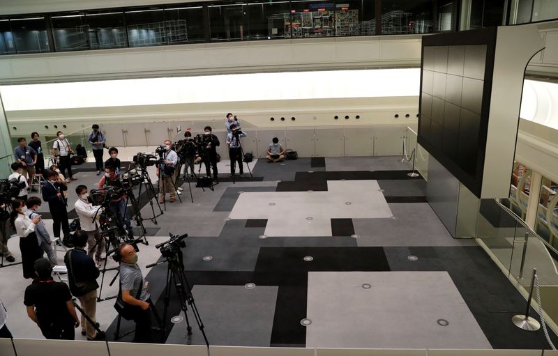 © Reuters. TV camera man wait for the opening of market  in front of a large screen showing stock prices at the Tokyo Stock Exchange in Tokyo