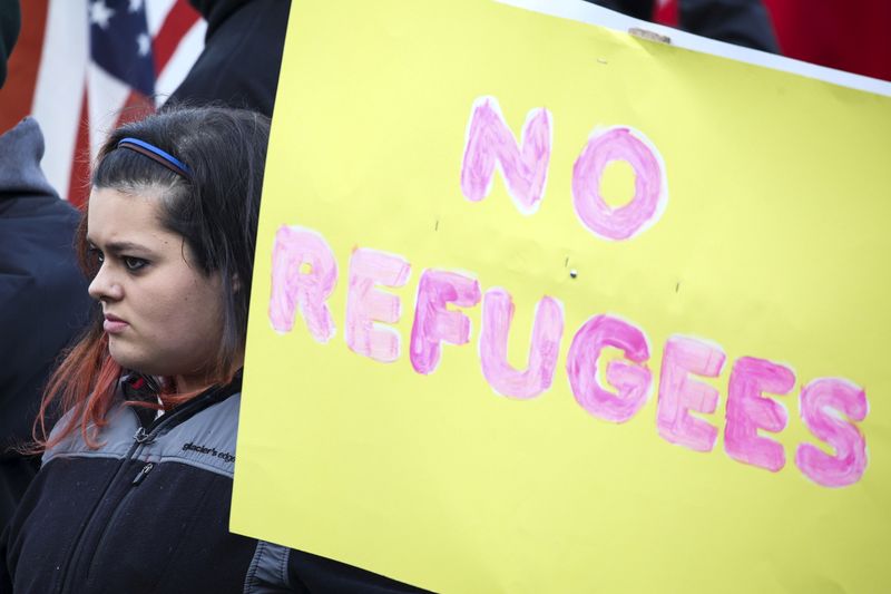 &copy; Reuters. FOTO DE ARCHIVO: Un manifestante sostiene un cartel antirefugiados para protestar por la aceptación de los refugiados sirios por parte de Estados Unidos en la capital del estado de Washington, en Olimpia.