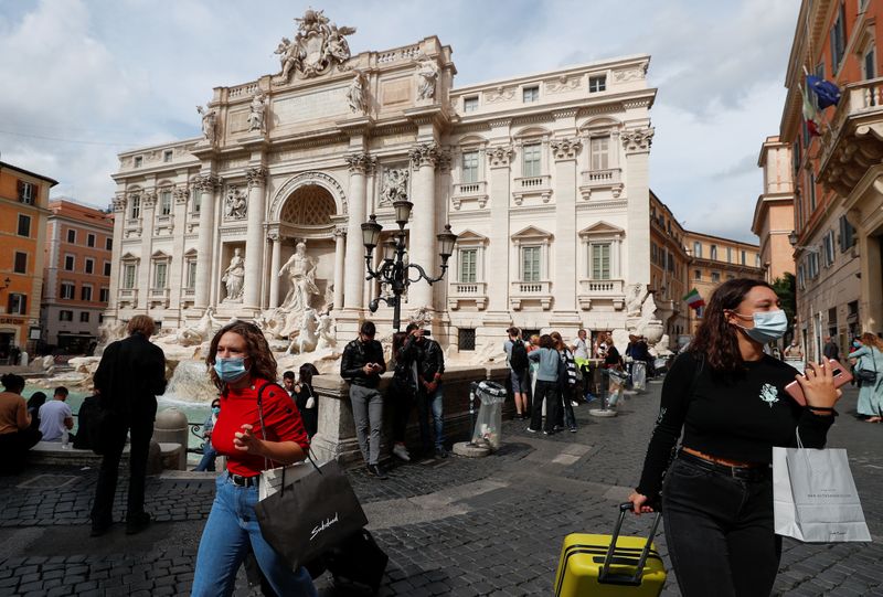 © Reuters. Pessoas usam máscaras de proteção perto da Fontana di Trevi, em Roma