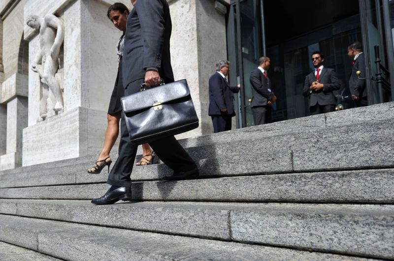 &copy; Reuters. Un uomo e una donna esce dalla sede della Borsa di Milano