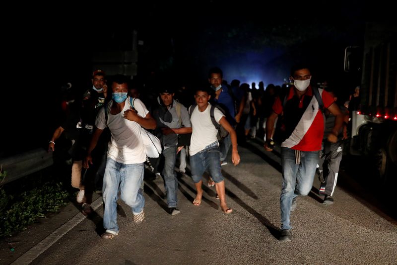 &copy; Reuters. Honduran migrants trying to reach the U.S. run away after hurling stones to Guatemalan soldiers blocking a road to stop migrants from reach the Mexico&apos;s border, in San Pedro Cadenas