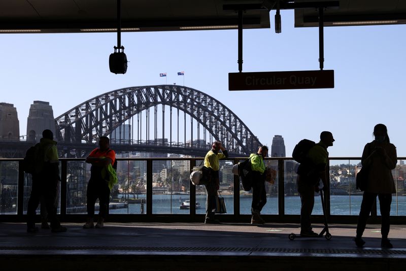 &copy; Reuters. Commuters wait on a train platform in front of the Sydney Harbour Bridge at Circular Quay in Sydney