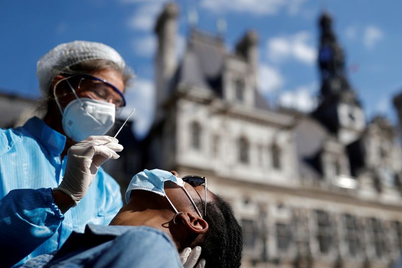 &copy; Reuters. FOTO DE ARCHIVO. Un trabajador de la salud, vestido con un traje protector y una mascarilla, se prepara para administrar un hisopo nasal a un paciente en un sitio de pruebas para la enfermedad del coronavirus (COVID-19) instalado frente al ayuntamiento de