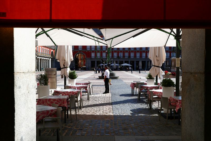 &copy; Reuters. FILE PHOTO: A waiter wearing a protective face mask waits for customers in his terrace at Plaza Mayor square amid the outbreak of the coronavirus disease (COVID-19) in Madrid