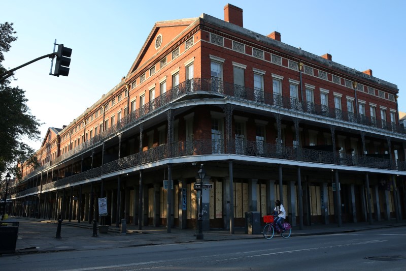 &copy; Reuters. FILE PHOTO: A man rides his bicycle past a boarded up business in the French Quarter amid the outbreak of the coronavirus disease (COVID-19), in New Orleans