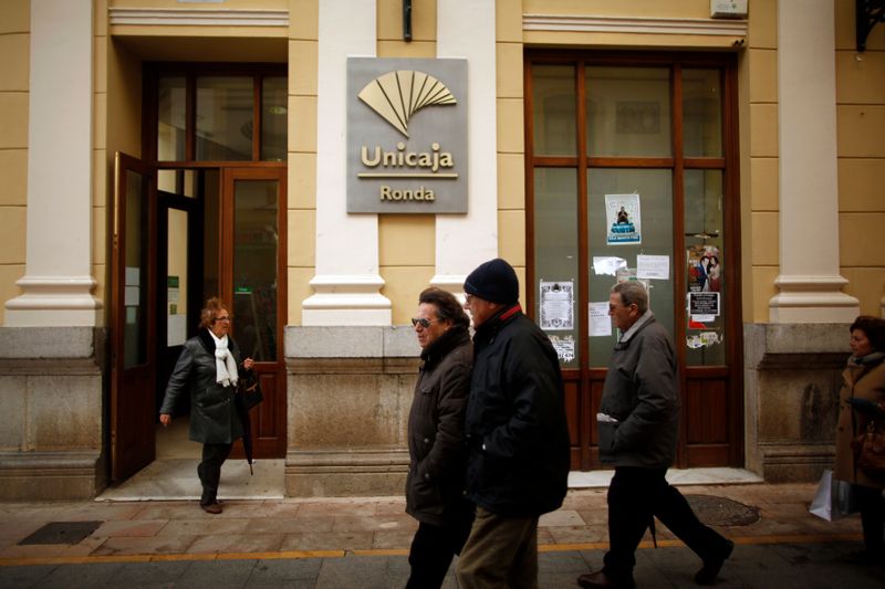 &copy; Reuters. FILE PHOTO: People walk past a Unicaja bank branch at La Bola street in downtown Ronda