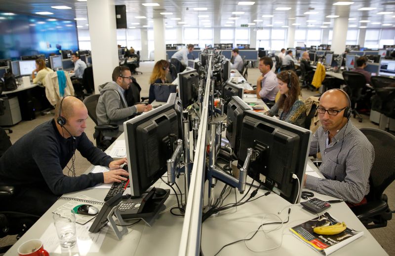 &copy; Reuters. Traders sit at their desks at IG Index in London