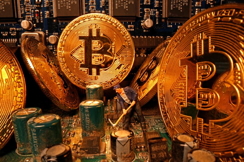 &copy; Reuters. A small toy figure and representations of the virtual currency Bitcoin stand on a motherboard in this picture illustration