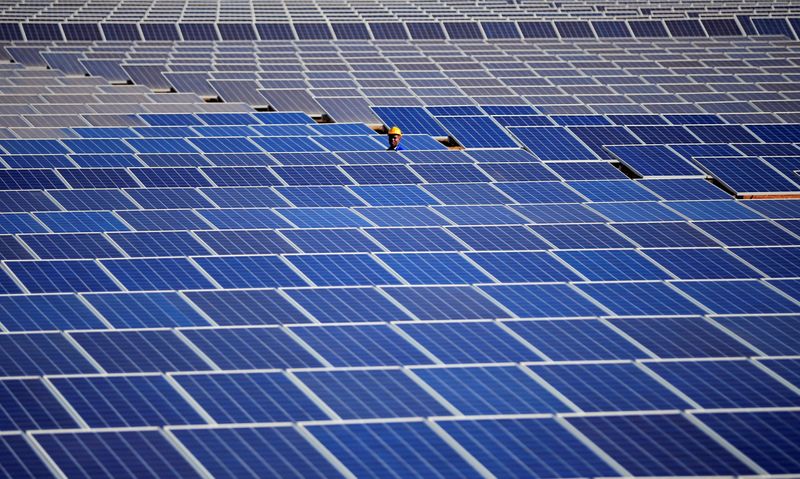 &copy; Reuters. A worker walks between solar panels at Centragrid power plant in Nyabira