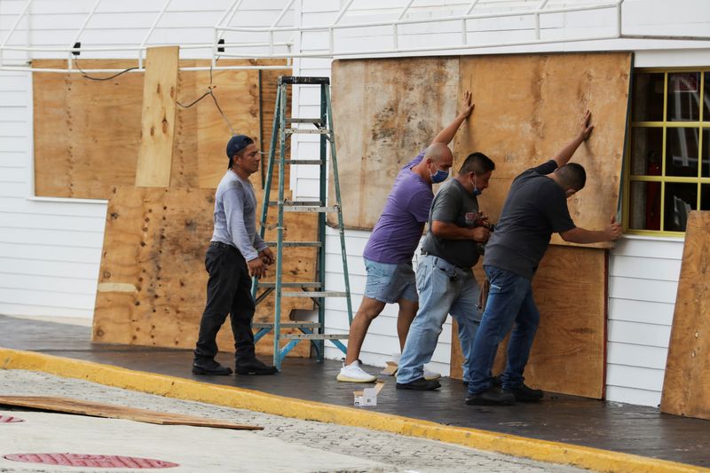 &copy; Reuters. Trabalhadores cobrem janelas de restaurante em Cancún antes da chegada de furacão Delta