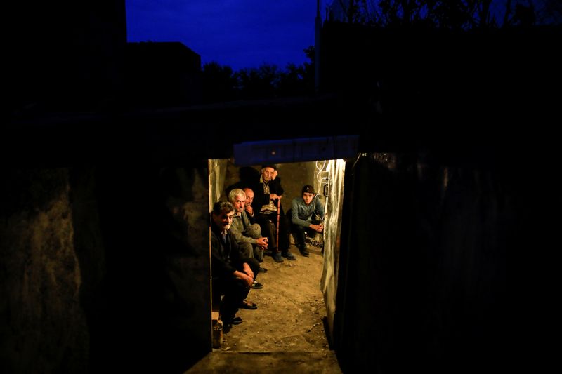 © Reuters. Local residents take shelter in a dugout during the fighting over the breakaway region of Nagorno-Karabakh in the city of Terter