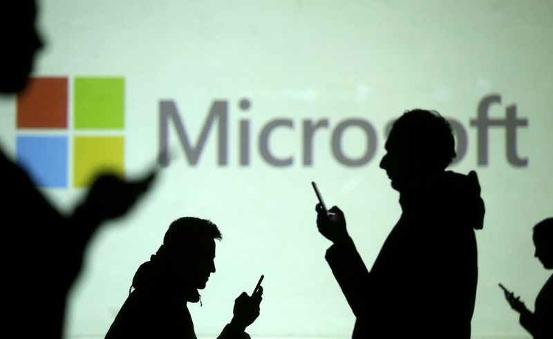 &copy; Reuters. Silhouettes of mobile users are seen next to a screen projection of Microsoft logo in this picture illustration