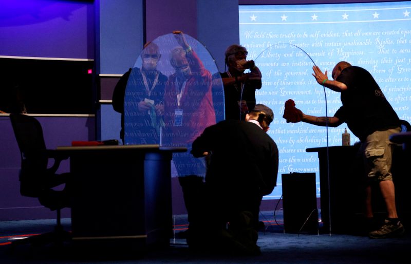 © Reuters. FILE PHOTO: Freshly installed plexiglass panels are cleaned onstage for the vice presidential debate in Salt Lake City