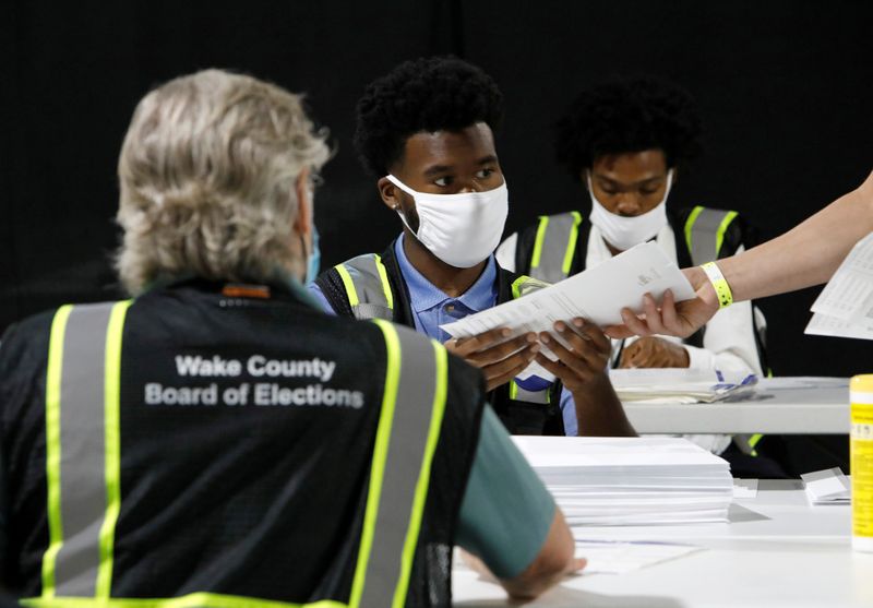 © Reuters. FILE PHOTO: : Poll workers prepare absentee ballots for the general election in Raleigh