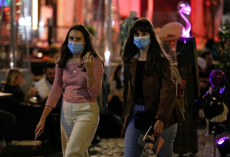 &copy; Reuters. Due ragazze indossano la mascherina dopo che le autorità locali ne hanno imposto l&apos;utilizzo anche all&apos;aperto per contenere la diffusione del coronavirus