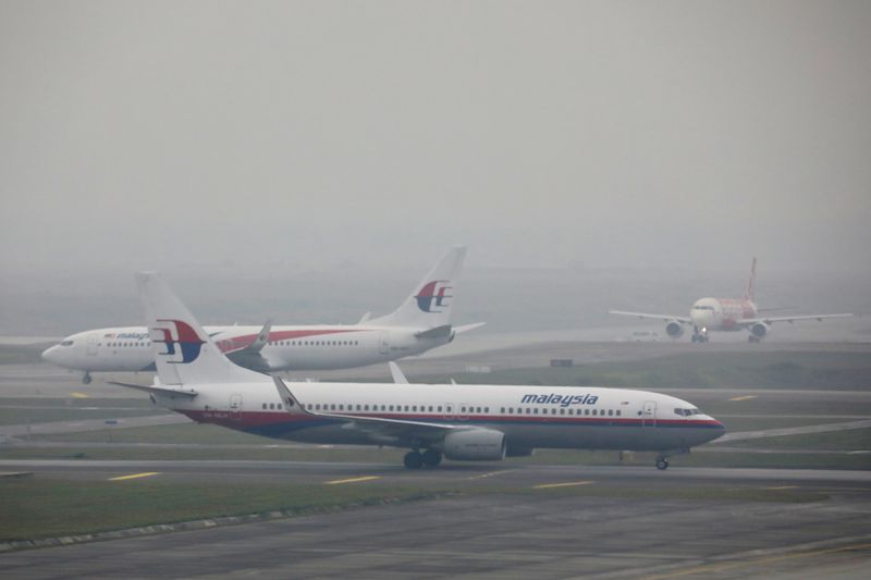 © Reuters. FILE PHOTO: Malaysia Airlines airplanes are pictured on the haze-shrouded tarmac at Kuala Lumpur International Airport in Sepang