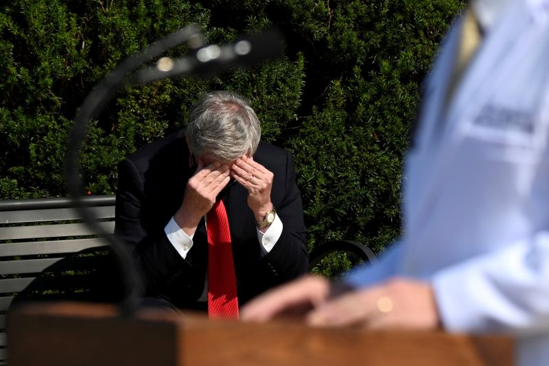 © Reuters. FILE PHOTO: White House Chief of Staff Mark Meadows rubs his head as U.S. Navy Commander Dr. Sean Conley speaks about U.S. President Donald Trump's health, in Bethesda