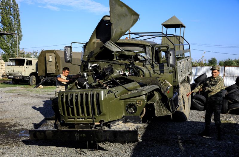 © Reuters. Soldiers inspect a damaged Armenian military truck seized by Azerbaijan army during the fighting over the breakaway region of Nagorno-Karabakh near the city of Barda