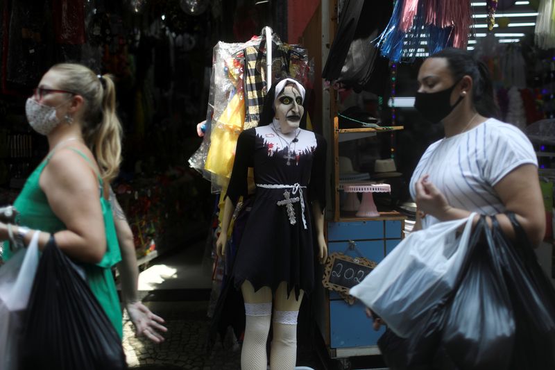 &copy; Reuters. Mulheres de máscara passam por lojas em centro comercial popular no centro do Rio de Janeiro