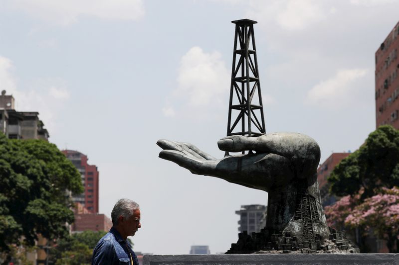 &copy; Reuters. A man walks past a sculpture outside a building of Venezuela&apos;s state oil company PDVSA in Caracas