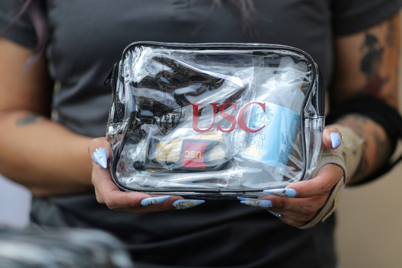 © Reuters. FILE PHOTO: A woman hands out sanitizer kits on the USC campus, amid the outbreak of the coronavirus disease (COVID-19), in Los Angeles