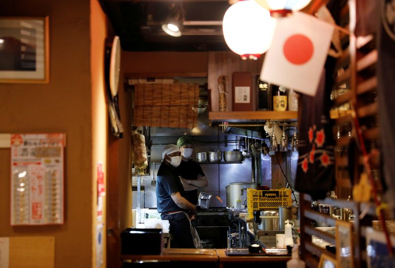 &copy; Reuters. Chefs wearing protective masks wait for customers at Toshirhin restaurant in Tokyo