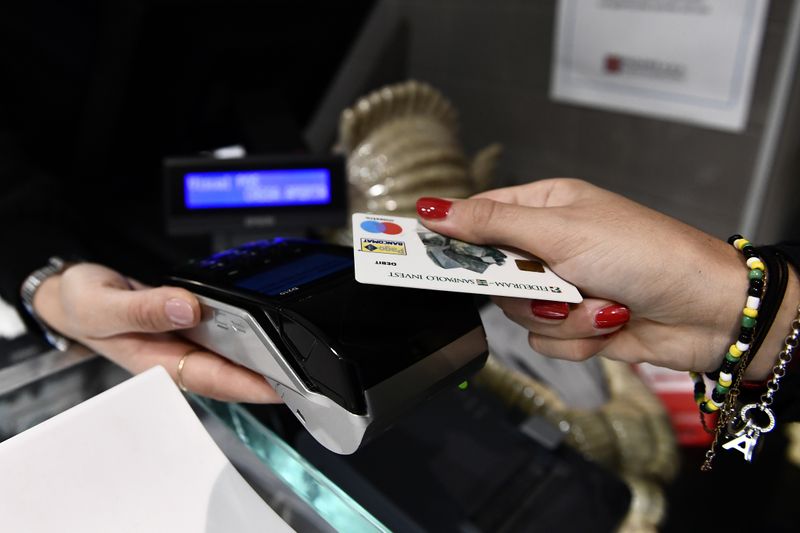 &copy; Reuters. Una donna paga il conto in un ristorante di Milano utilizzando la carta