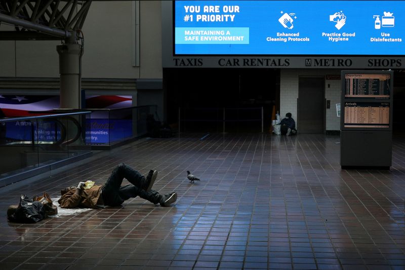 © Reuters. FILE PHOTO: Homeless people lay outside of an Amtrak commuter train platform at Washington Union Station, following Mayor Muriel Bowser's state of emergency declaration due to the coronavirus disease (COVID-19) pandemic, in Washington