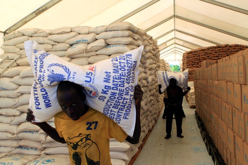 &copy; Reuters. Pessoas carregam sacos de alimentos do Programa Mundial de Alimentos da ONU em assentamento para refugiados do Sudão do Sul em Uganda