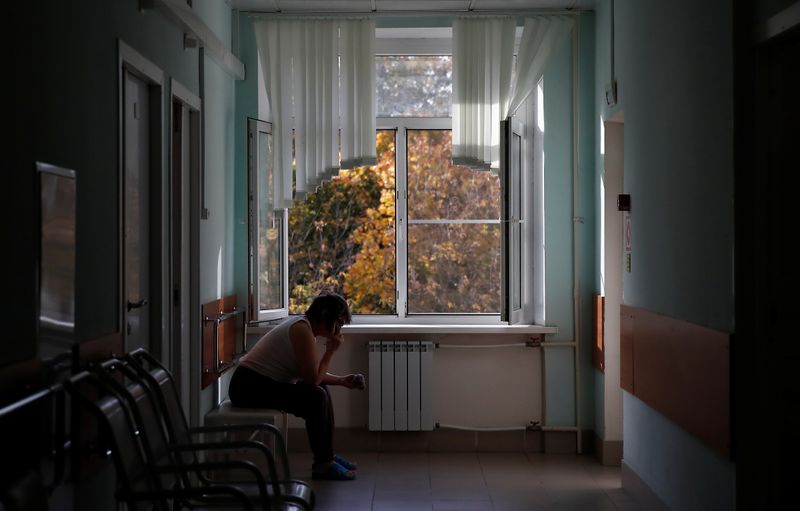 &copy; Reuters. Una donna parla al telefono vicino alla finestra dell&apos;ospedale City Clinical, dove vengono trattati i pazienti affetti dal coronavirus, a Mosca, 8 ottobre 2020