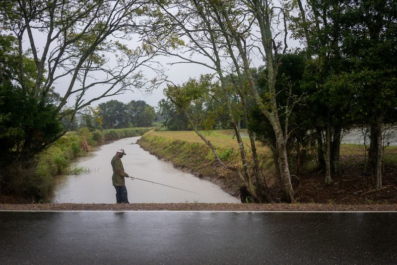 © Reuters. Eric Alexis fishes as Hurricane Delta approaches near Perry