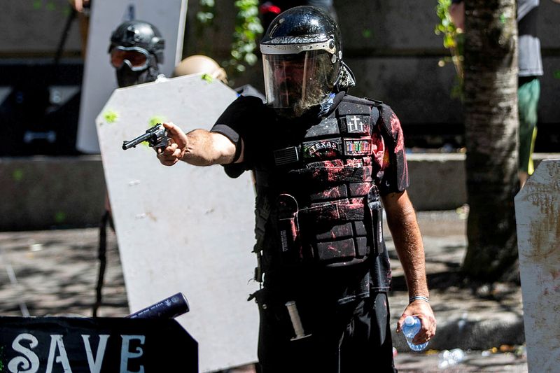 © Reuters. Homem aponta arma durante confronto entre grupos de apoio à polícia e manifestantes contrários à brutalidade policial nos EUA em Portland, no Oregon