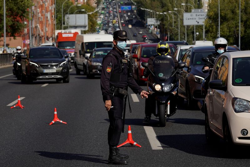 &copy; Reuters. FOTO DE ARCHIVO: Un agente de la Policía Nacional Española con una mascarilla protectora en un puesto de control de tráfico durante el confinamiento parcial en medio del brote de coronavirus, en Madrid