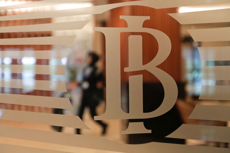 &copy; Reuters. A woman walks behind a logo of Indonesia&apos;s central bank, Bank Indonesia, in Jakarta